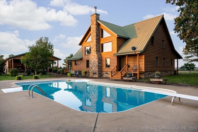 pool featuring a patio area and a diving board