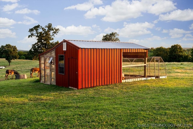 view of outbuilding featuring a rural view and a yard