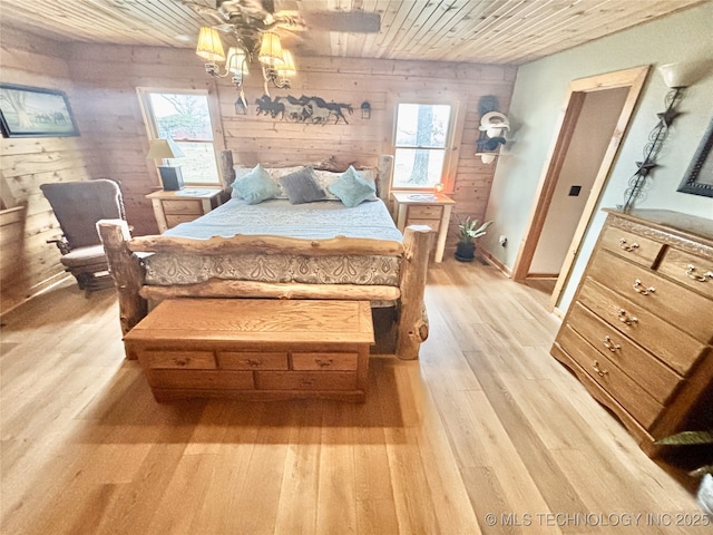 bedroom featuring wooden ceiling, wood walls, and light wood finished floors