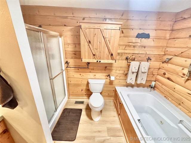 full bath with toilet, a shower stall, visible vents, and wood finished floors