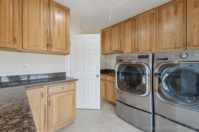 washroom featuring washer and clothes dryer, cabinets, and light tile patterned floors