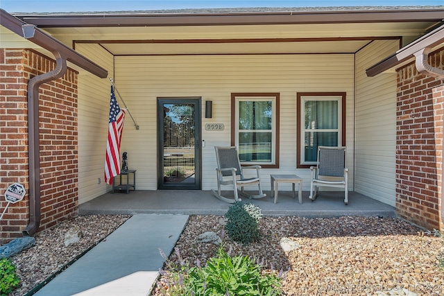 view of exterior entry featuring covered porch