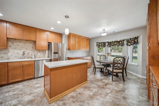 kitchen with tasteful backsplash, a kitchen island, stainless steel appliances, sink, and decorative light fixtures