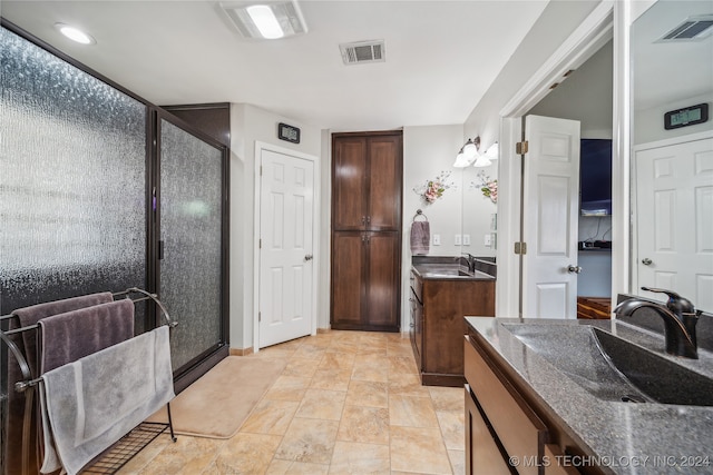 bathroom with a shower with door and vanity