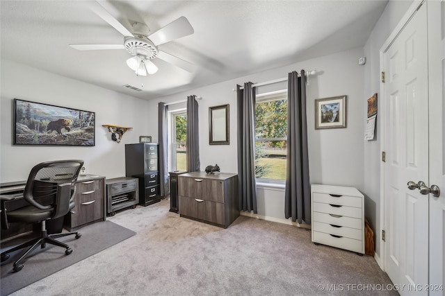 carpeted office space featuring ceiling fan