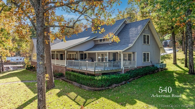 rear view of house featuring a wooden deck and a yard