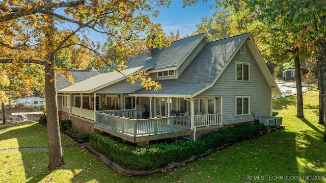 back of property with a wooden deck, a lawn, and central AC unit