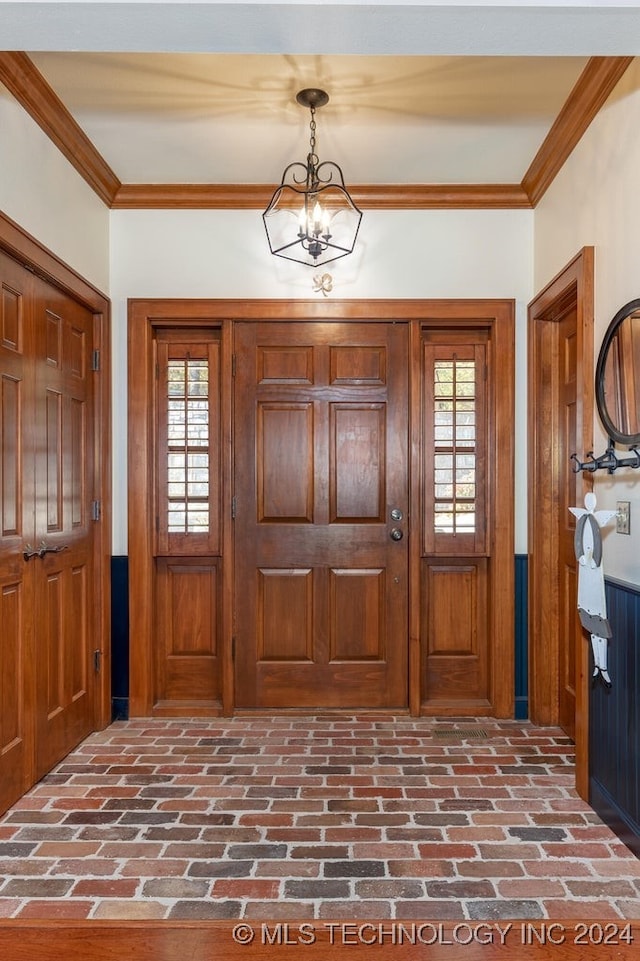 entryway featuring crown molding and a notable chandelier