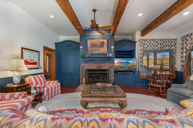 living room with dark hardwood / wood-style flooring, beam ceiling, a fireplace, and ceiling fan