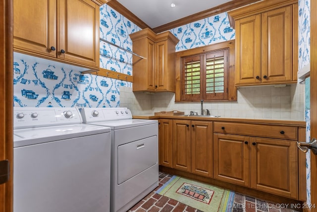 clothes washing area with sink, washer and dryer, and cabinets