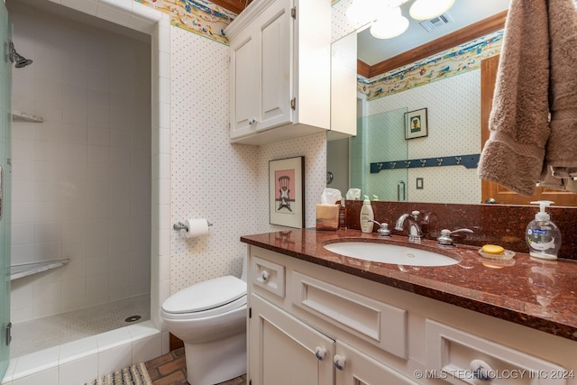 bathroom with vanity, toilet, and tiled shower