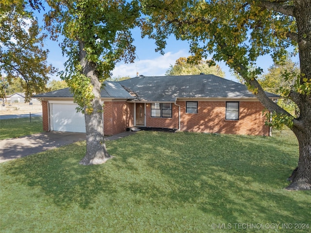 ranch-style house featuring a front yard and a garage