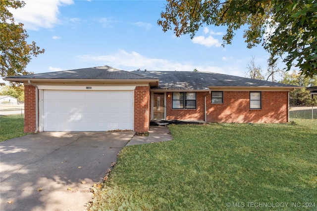 single story home with a garage and a front lawn