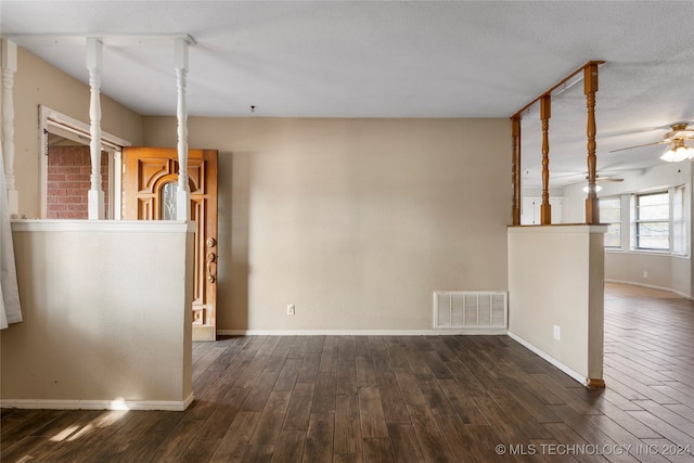 spare room with a textured ceiling, ceiling fan, and dark hardwood / wood-style flooring