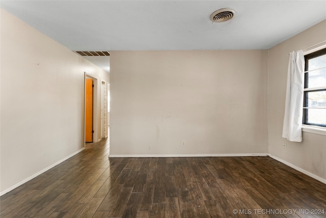 unfurnished room with dark wood-type flooring