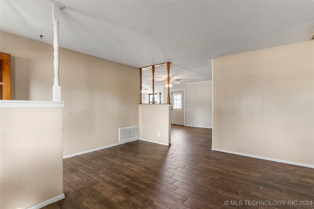 spare room featuring dark wood-type flooring, ceiling fan, and a textured ceiling