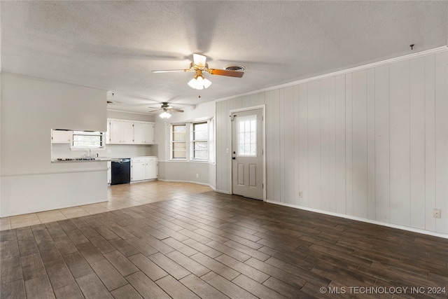 unfurnished living room featuring ceiling fan, hardwood / wood-style flooring, and a textured ceiling