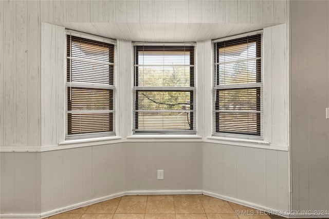 spare room with wood walls and light tile patterned flooring