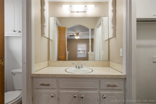 bathroom featuring toilet, vanity, and ceiling fan