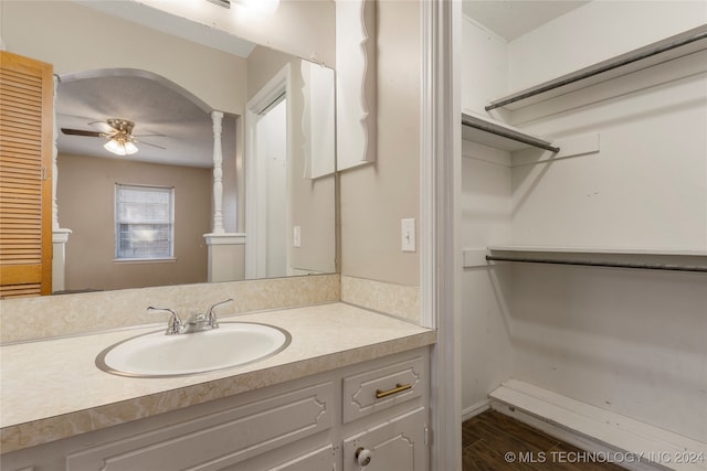 bathroom with vanity, hardwood / wood-style flooring, ornate columns, and ceiling fan