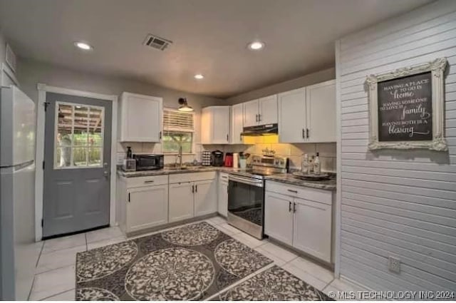 kitchen with white cabinetry, white fridge, and stainless steel electric range oven