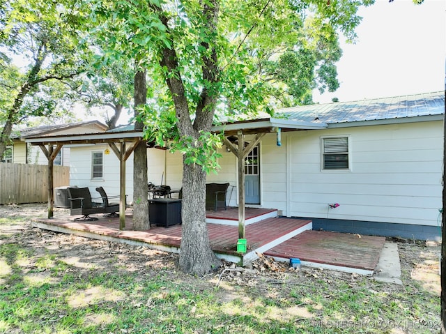 back of house with central air condition unit and a wooden deck