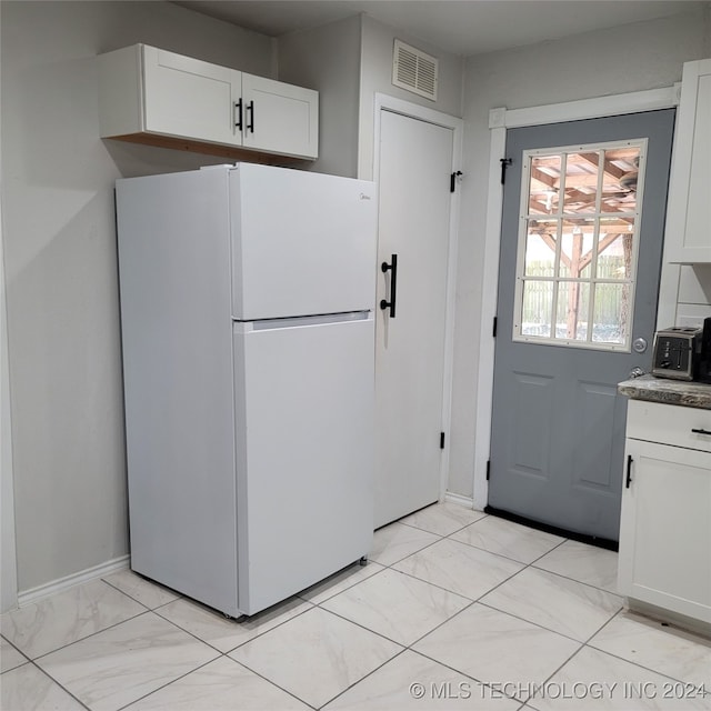 kitchen featuring white fridge and white cabinets