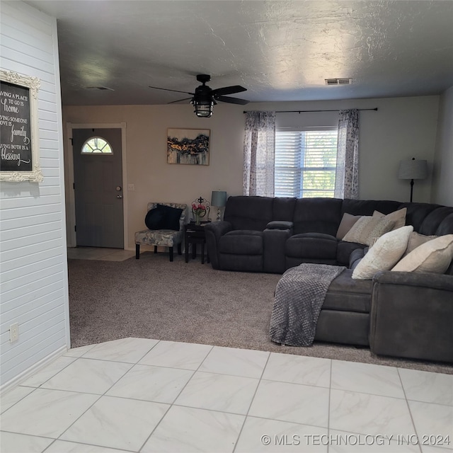 living room with light carpet, a textured ceiling, and ceiling fan