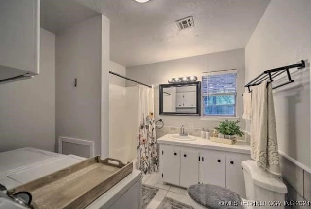 bathroom featuring vanity, a shower with curtain, toilet, and tile patterned floors