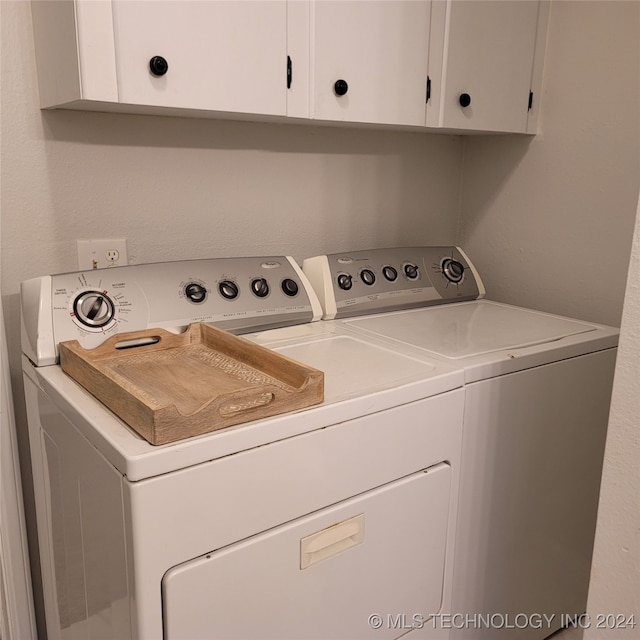 laundry room with cabinets and washing machine and clothes dryer