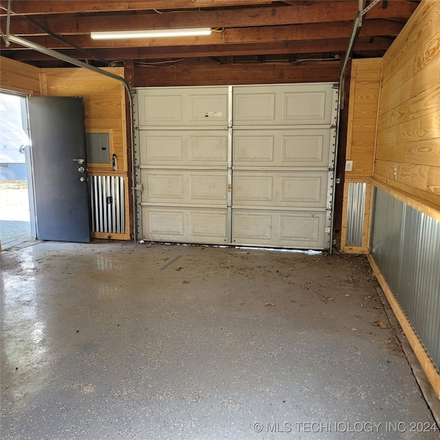 garage featuring electric panel and wooden walls