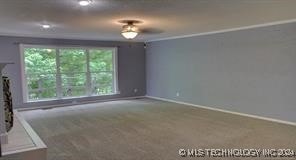 unfurnished living room with crown molding and carpet floors