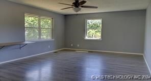 spare room featuring ceiling fan, dark hardwood / wood-style floors, and plenty of natural light