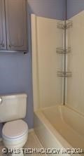 bathroom featuring plus walk in shower and toilet