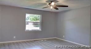 unfurnished room featuring hardwood / wood-style flooring and ceiling fan