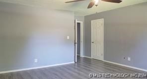 empty room featuring ceiling fan and dark hardwood / wood-style flooring