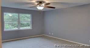 carpeted empty room featuring ceiling fan