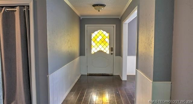 entryway with dark wood-type flooring and crown molding