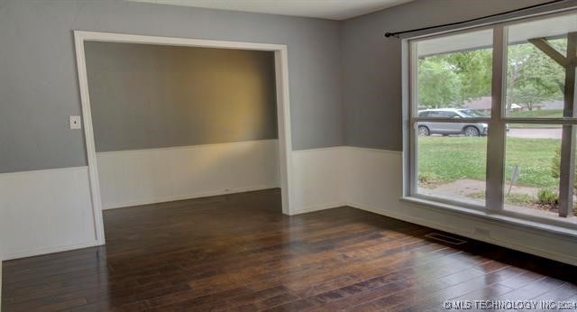 unfurnished room with dark wood-type flooring