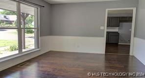 unfurnished room with dark hardwood / wood-style floors and plenty of natural light