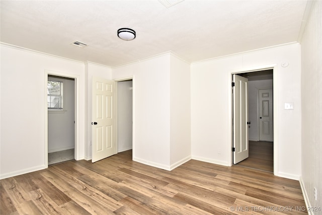 unfurnished room with ornamental molding and hardwood / wood-style floors