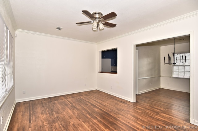 unfurnished room featuring ceiling fan with notable chandelier, crown molding, and dark hardwood / wood-style floors