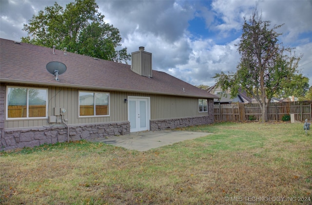 back of property featuring french doors, a patio area, and a lawn