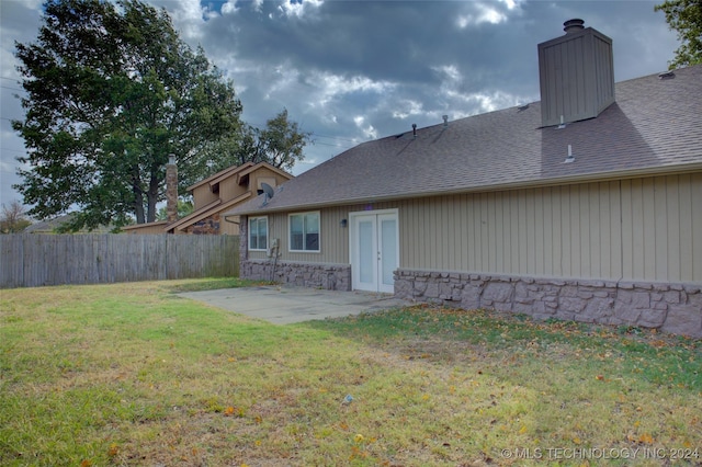 rear view of house with a lawn and a patio area