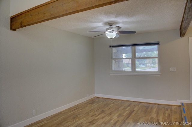 spare room with ceiling fan, wood-type flooring, and a textured ceiling