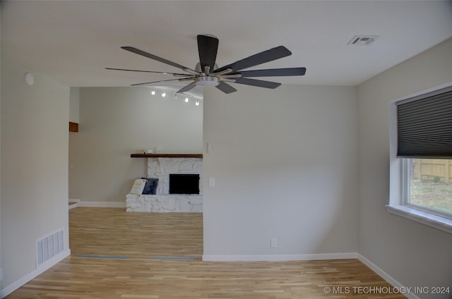 unfurnished living room featuring light hardwood / wood-style flooring, a fireplace, and ceiling fan