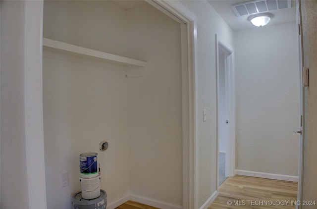 laundry room featuring hardwood / wood-style flooring and a textured ceiling