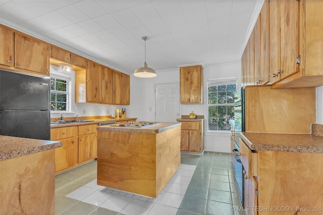 kitchen with a healthy amount of sunlight, a kitchen island, pendant lighting, and black fridge