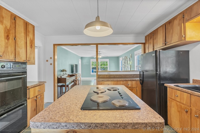 kitchen featuring ornamental molding, decorative light fixtures, black appliances, and a kitchen island