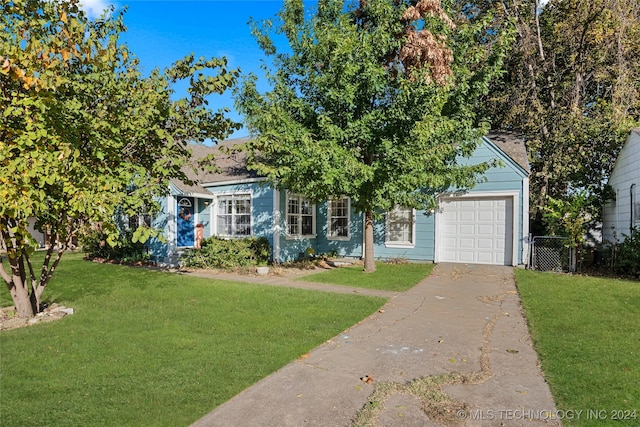 view of property hidden behind natural elements with a front lawn and a garage